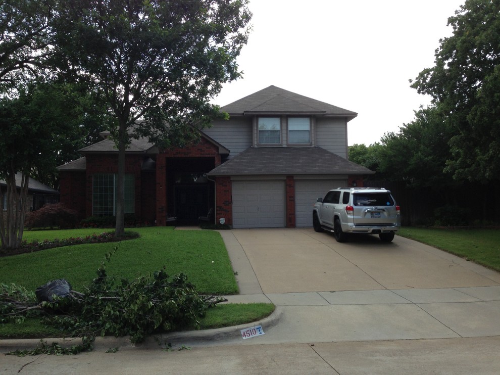 Photo of a large and gey traditional split-level brick house exterior in Dallas.