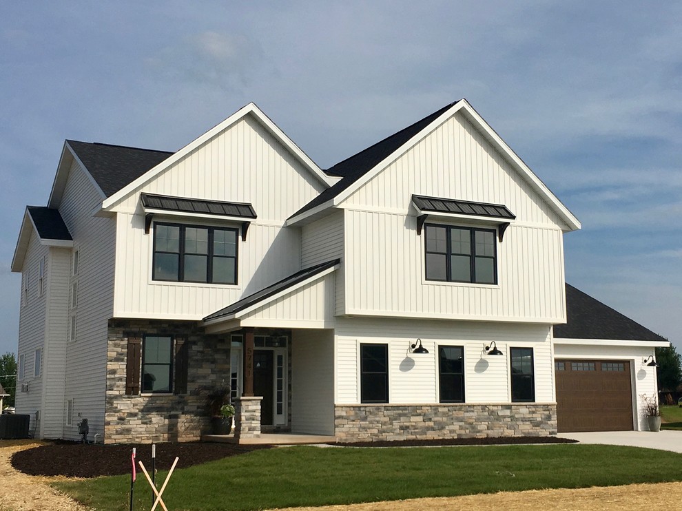 Mittelgroßes, Zweistöckiges Landhaus Einfamilienhaus mit Mix-Fassade, weißer Fassadenfarbe, Satteldach und Misch-Dachdeckung in Sonstige