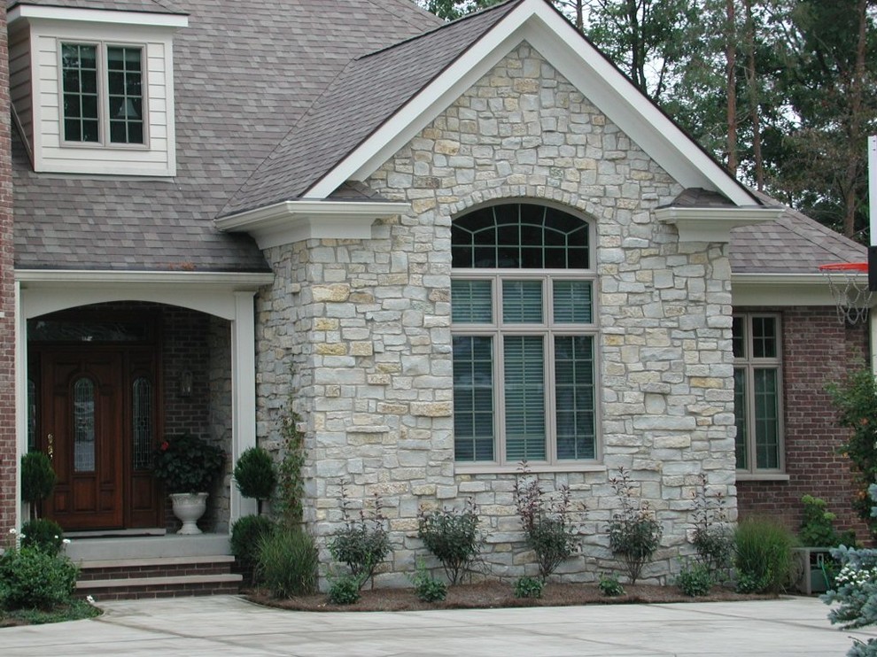 Example of an arts and crafts beige two-story stone exterior home design in Indianapolis