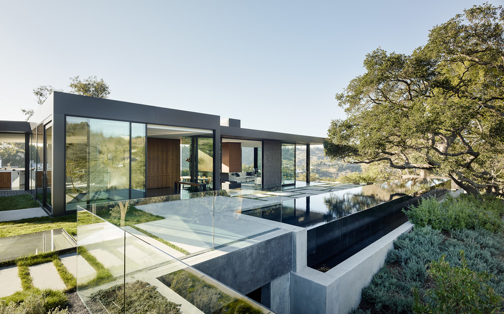 Gey contemporary bungalow glass house exterior in Los Angeles with a flat roof.