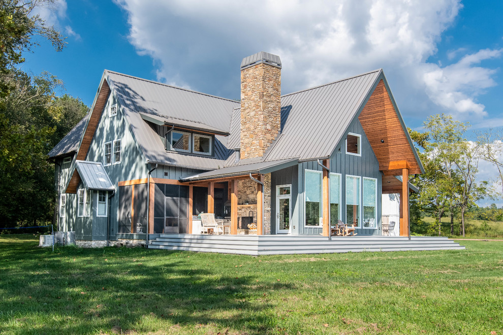 Foto della villa blu country a due piani di medie dimensioni con rivestimento in legno, tetto a capanna e copertura in metallo o lamiera