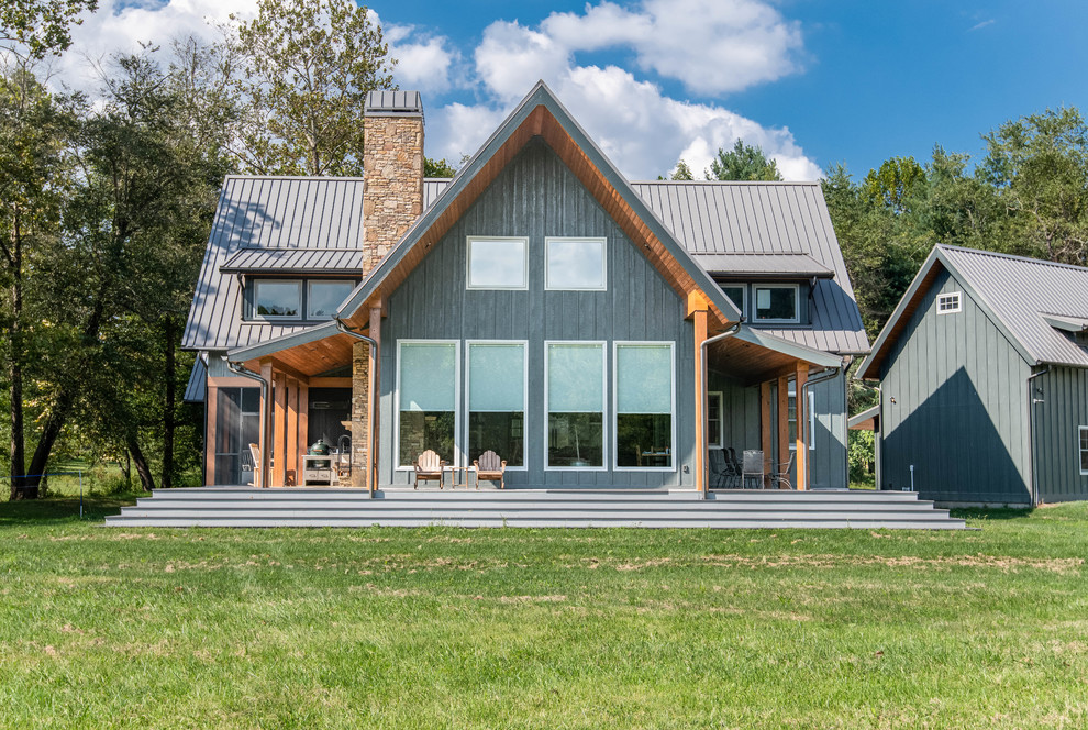 Immagine della villa blu country a due piani di medie dimensioni con rivestimento in legno, tetto a capanna e copertura in metallo o lamiera