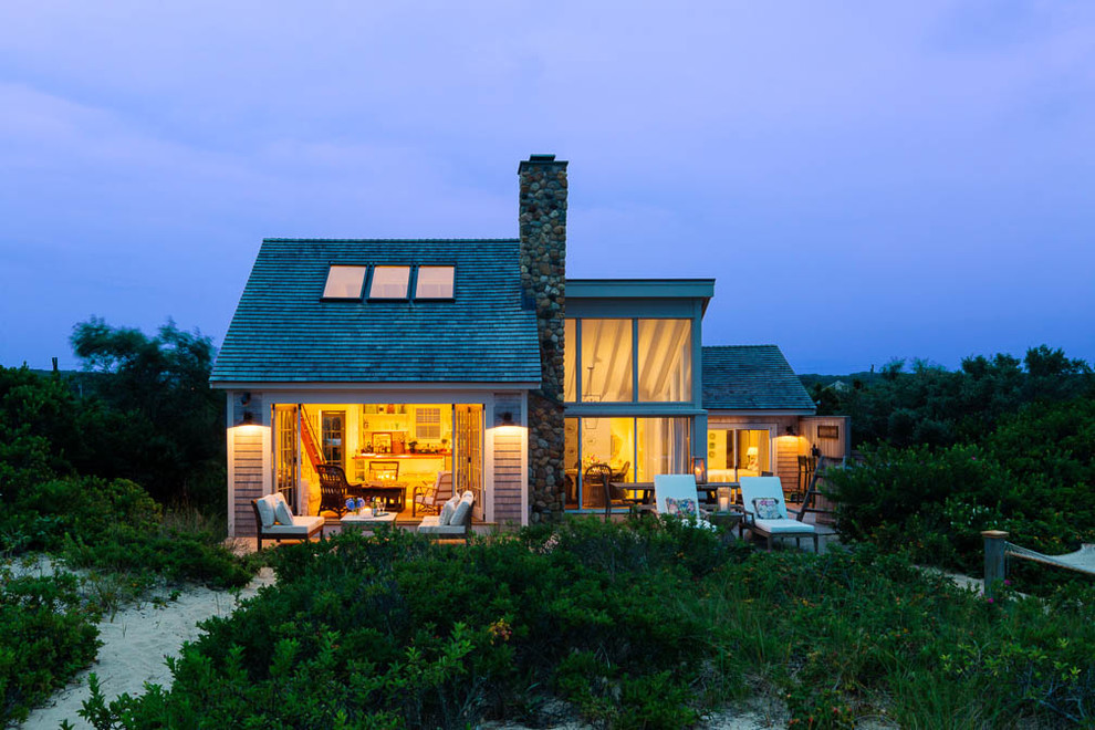 Aménagement d'une façade de maison beige bord de mer de taille moyenne et à un étage avec un revêtement en vinyle et un toit à deux pans.