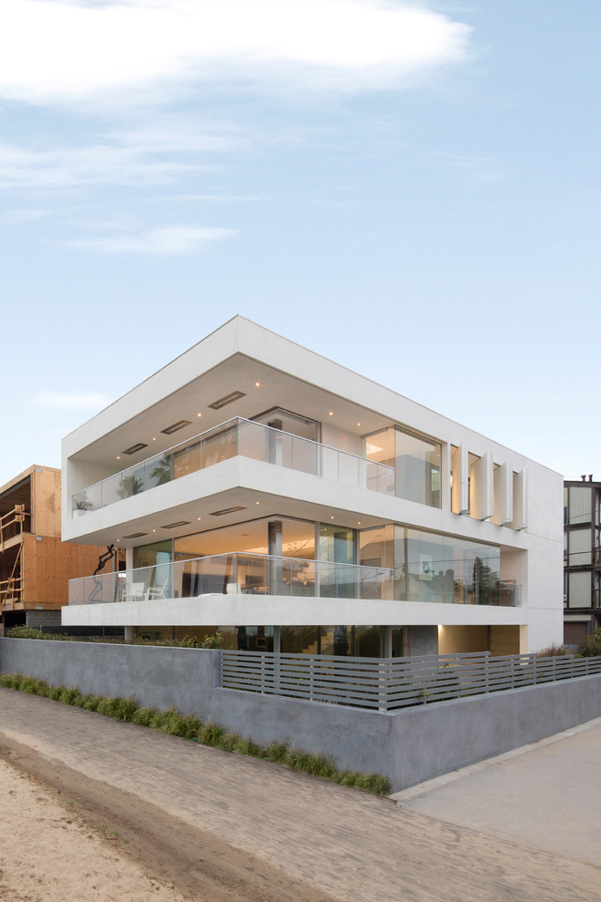 Inspiration for a large and white modern render house exterior in Los Angeles with three floors.