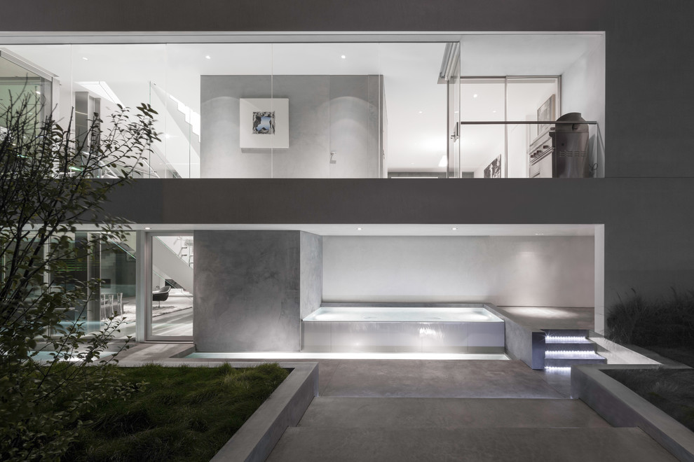 Modelo de fachada blanca minimalista grande de tres plantas con revestimiento de estuco
