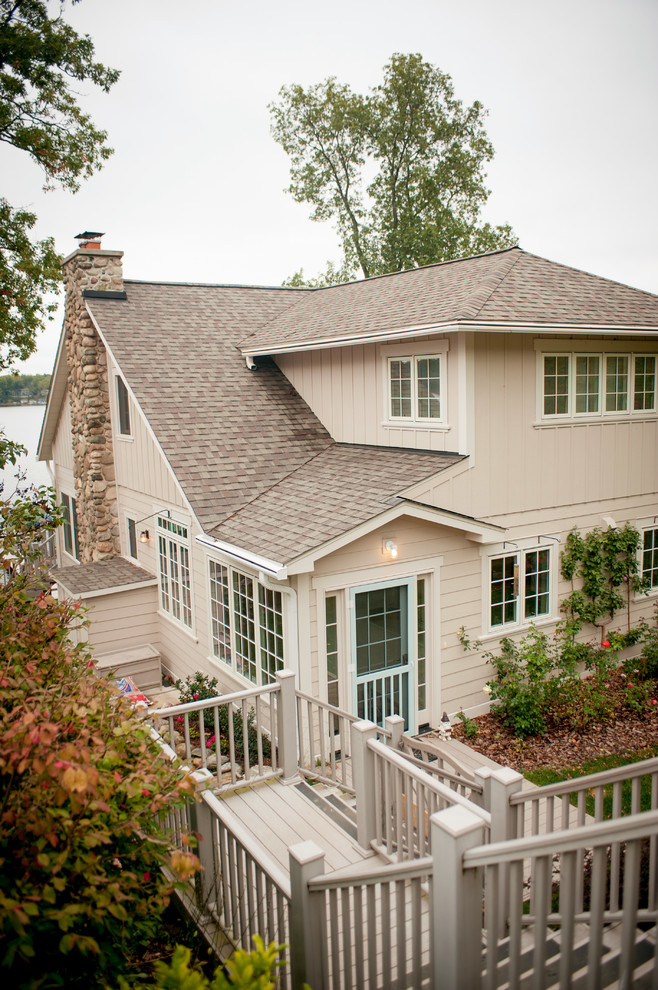 Cette photo montre une grande façade de maison beige bord de mer en panneau de béton fibré à deux étages et plus avec un toit à deux pans.