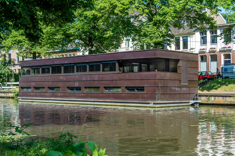 Diseño de fachada marrón industrial de tamaño medio de dos plantas con revestimiento de metal y tejado plano