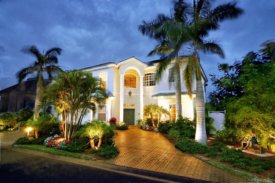 Ejemplo de fachada de casa beige tropical de tamaño medio de una planta con revestimiento de estuco, tejado a cuatro aguas y tejado de teja de barro