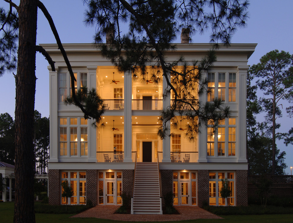 На фото: трехэтажный, белый дом в классическом стиле с комбинированной облицовкой с