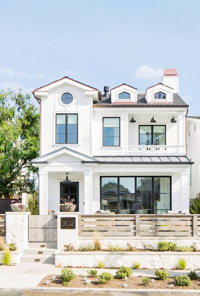 Inspiration for a large country white three-story exterior home remodel in Orange County with a mixed material roof