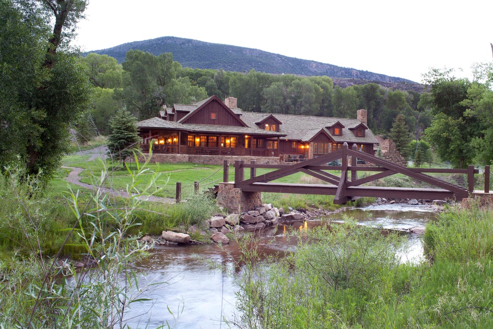 This is an example of a large and brown rustic two floor house exterior in Denver.