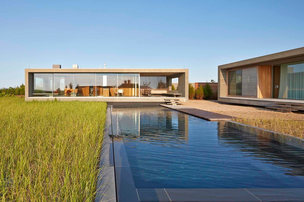 Стильный дизайн: одноэтажный, бежевый дом в стиле модернизм с плоской крышей - последний тренд