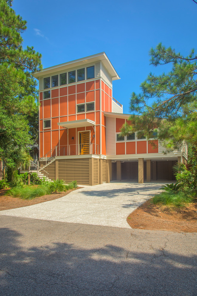 Пример оригинального дизайна: трехэтажный, оранжевый частный загородный дом в морском стиле с комбинированной облицовкой