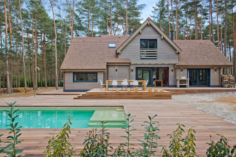 Cette image montre une façade de maison grise design en bois à un étage et de taille moyenne avec un toit à deux pans.
