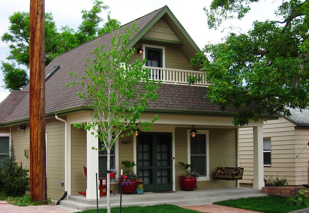 Cette photo montre une petite façade de maison beige chic à un étage avec un revêtement mixte et un toit à deux pans.