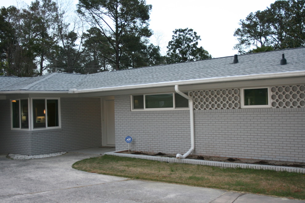 Diseño de fachada de casa gris vintage de tamaño medio de una planta con revestimiento de ladrillo, tejado a cuatro aguas y tejado de teja de madera