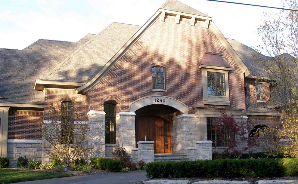 Inspiration for a large timeless red two-story brick house exterior remodel in Detroit