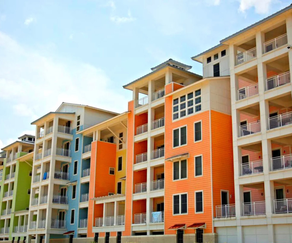 Immagine della facciata di un appartamento multicolore stile marinaro a tre piani di medie dimensioni con rivestimento con lastre in cemento, tetto a capanna e copertura in metallo o lamiera