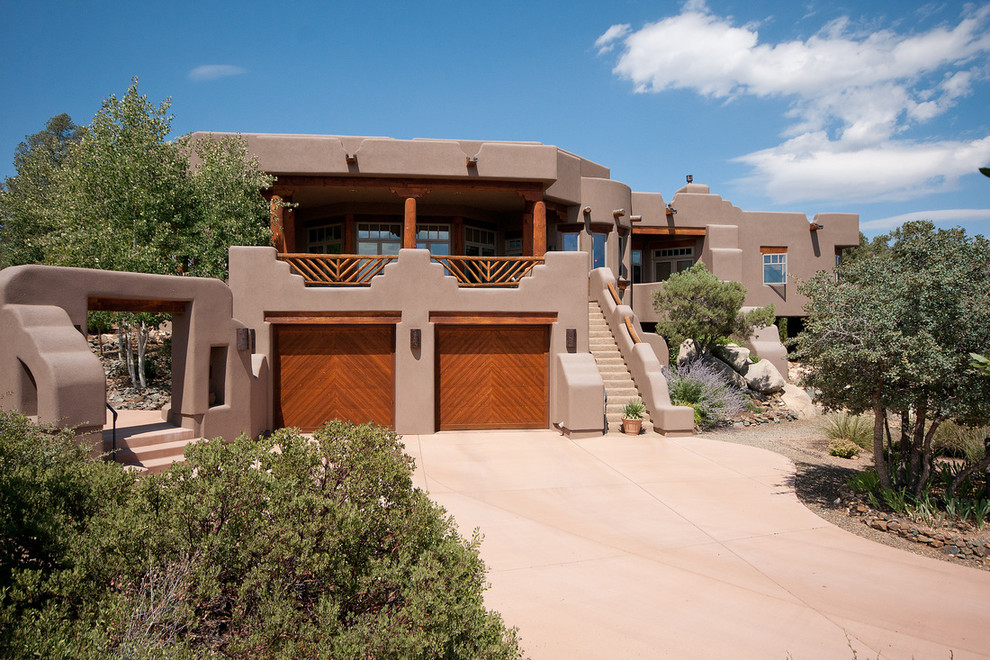 На фото: огромный, двухэтажный, коричневый дом в стиле фьюжн с облицовкой из цементной штукатурки и плоской крышей