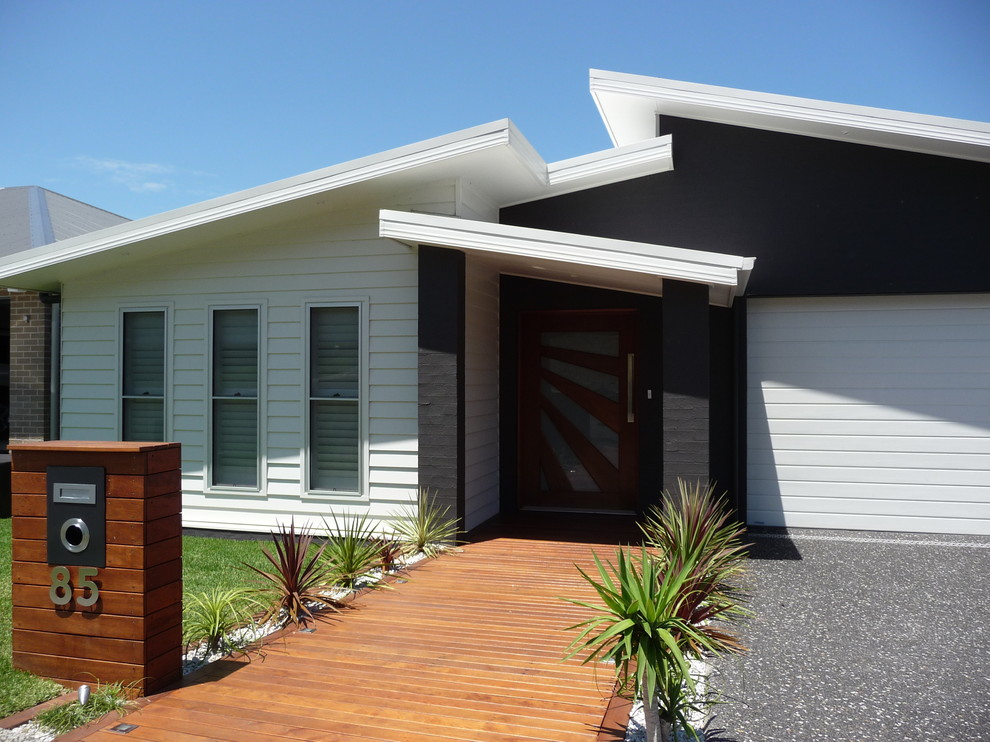 Idée de décoration pour une façade de maison blanche marine de taille moyenne et à niveaux décalés avec un revêtement mixte.