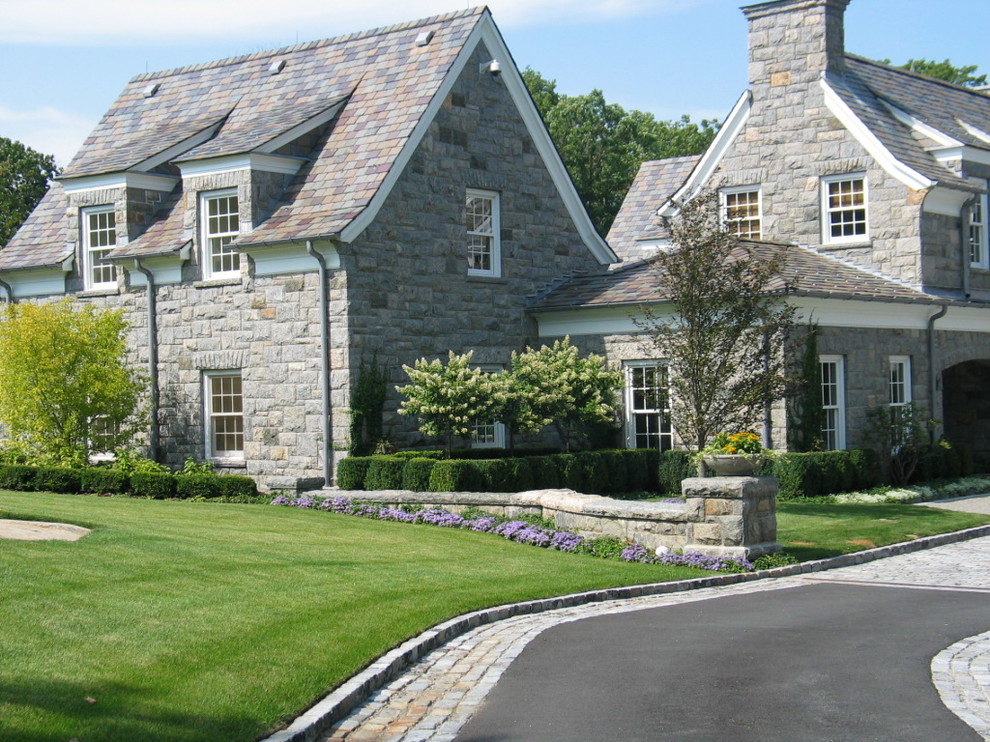 Cette image montre une façade de maison grise traditionnelle en pierre à un étage.