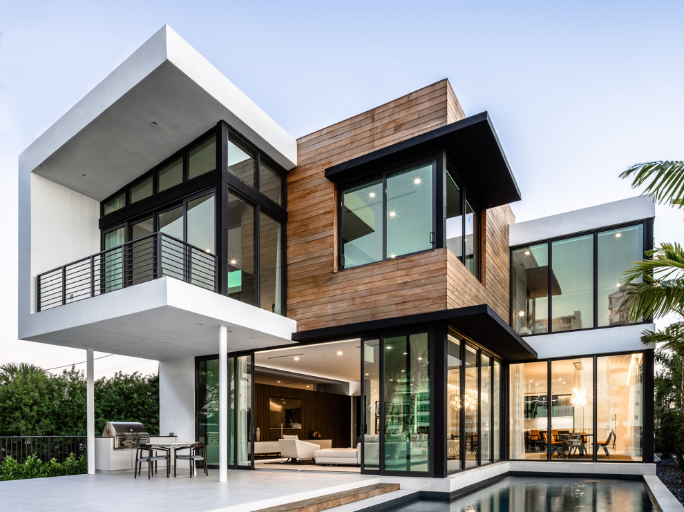 Réalisation d'une grande façade de maison blanche design en bois à un étage avec un toit plat.