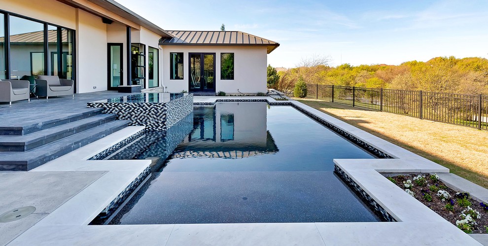 This is an example of a medium sized and white contemporary bungalow clay house exterior in Dallas with a flat roof.