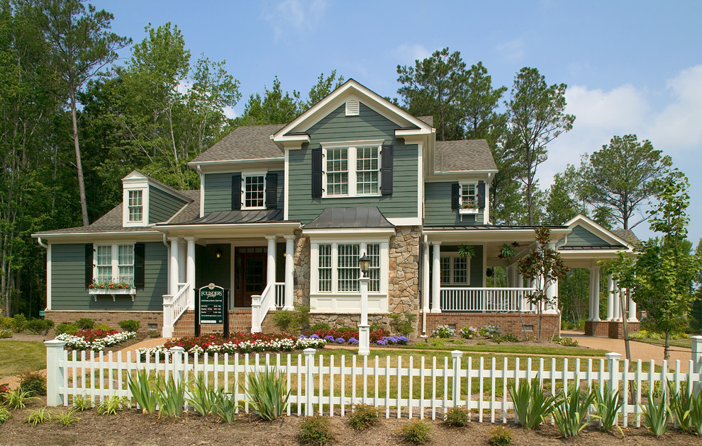 Foto della facciata di una casa grande verde classica a due piani con rivestimento in legno e tetto a capanna