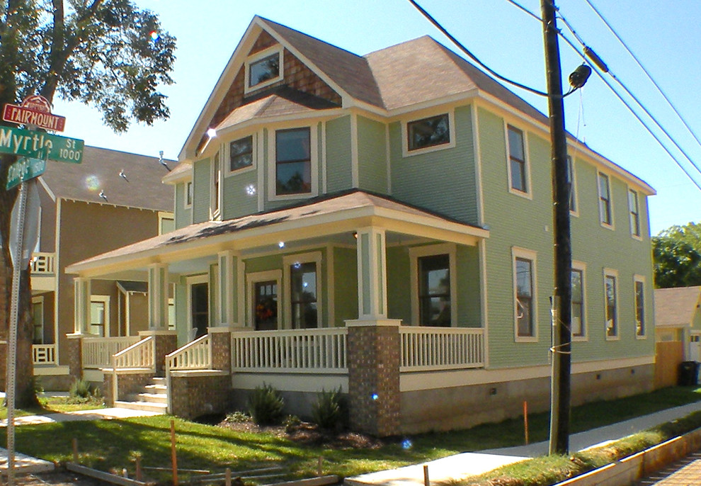 Aménagement d'une façade de maison verte classique en bois de taille moyenne et à un étage.