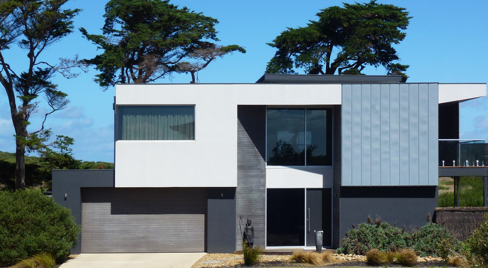 Ejemplo de fachada de casa gris moderna grande de dos plantas con revestimientos combinados, tejado plano y tejado de metal