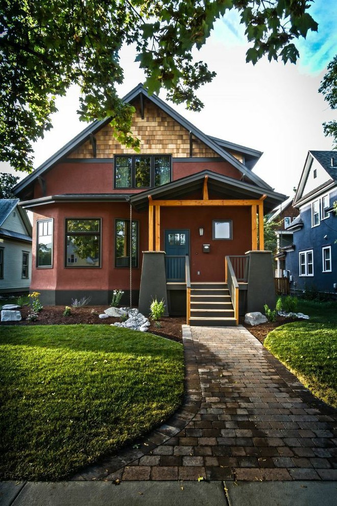 На фото: двухэтажный, красный дом среднего размера в стиле кантри с облицовкой из цементной штукатурки и двускатной крышей с