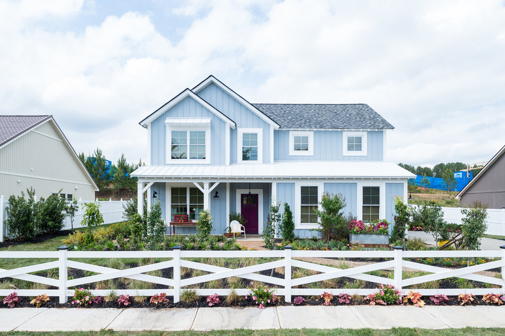 Cette photo montre une façade de maison bleue nature de taille moyenne et à un étage avec un toit en shingle.
