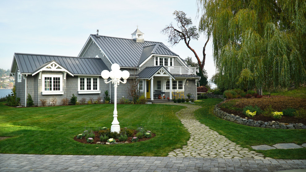 На фото: двухэтажный, деревянный, серый частный загородный дом среднего размера в морском стиле с полувальмовой крышей и металлической крышей с