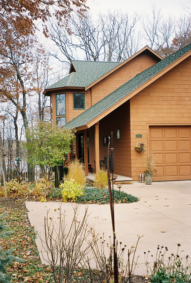 Imagen de fachada de casa marrón contemporánea de tamaño medio de tres plantas con tejado a dos aguas, revestimiento de madera y tejado de teja de madera