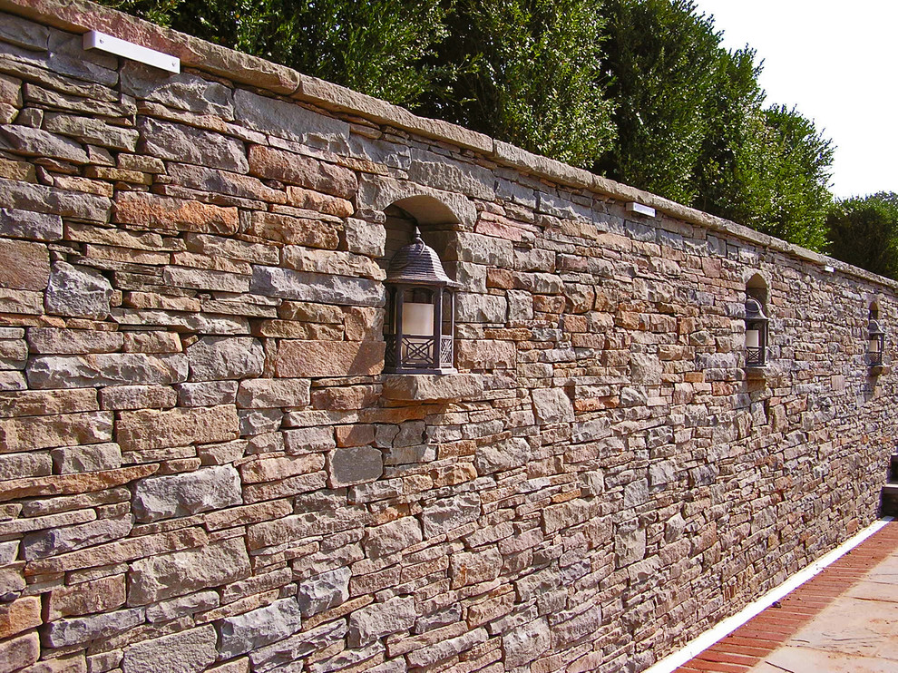 Esempio della facciata di una casa grande beige classica a due piani con rivestimento in pietra