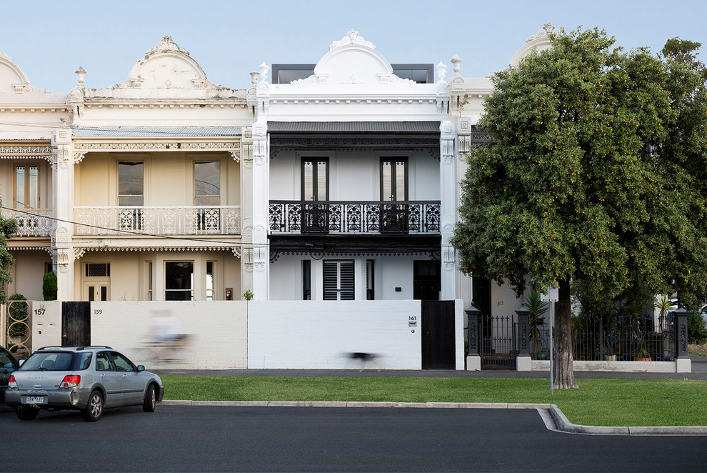 Modelo de fachada de casa clásica de tamaño medio de tres plantas con tejado de metal