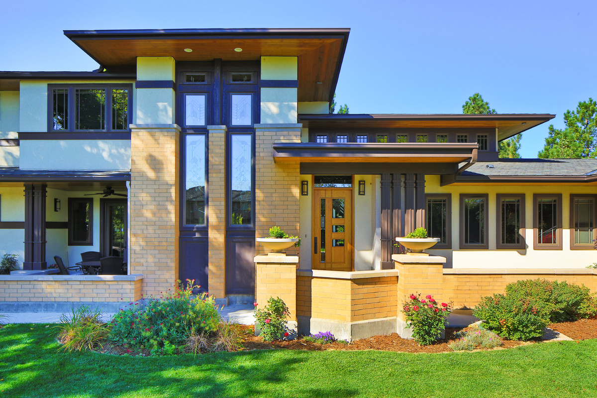Imagen de fachada de casa multicolor de estilo americano de dos plantas con revestimientos combinados y tejado de teja de madera