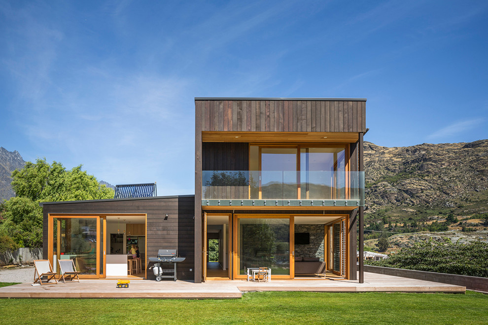 Ejemplo de fachada marrón contemporánea a niveles con revestimiento de madera y tejado plano
