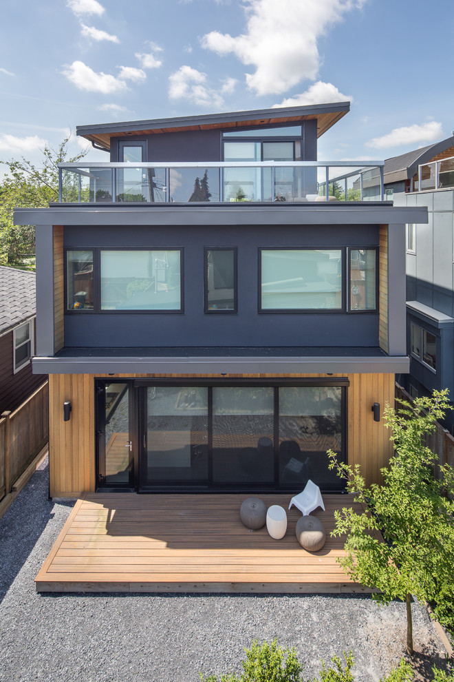 Mid-sized minimalist multicolored two-story mixed siding house exterior photo in Vancouver with a shed roof