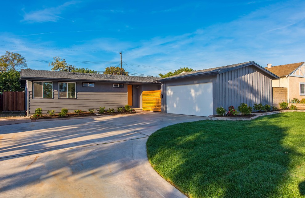 Mid-century modern gray one-story exterior home photo in Orange County with a shingle roof