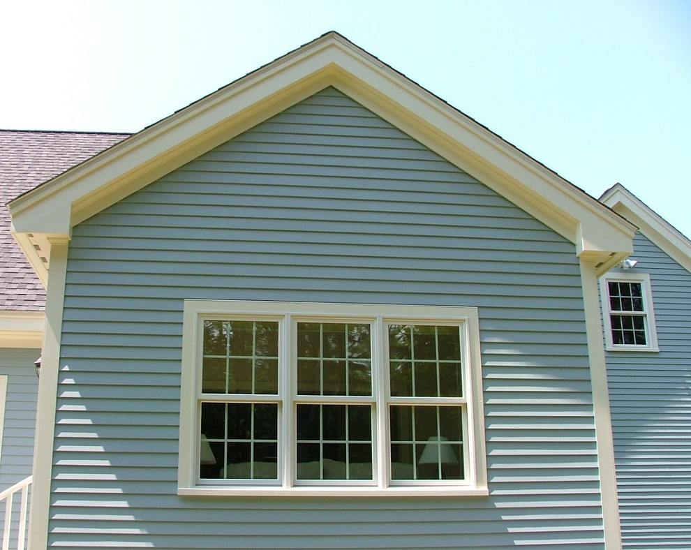 Cette photo montre une grande façade de maison bleue chic en bois à un étage.