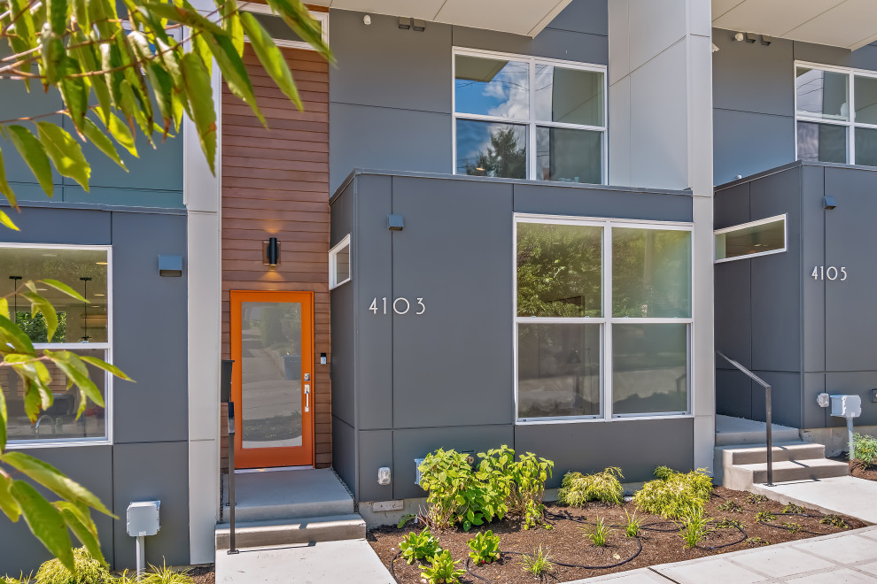 Imagen de fachada de casa pareada gris minimalista de tamaño medio de tres plantas con revestimientos combinados y tejado plano