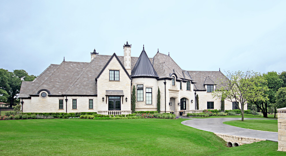 На фото: двухэтажный, большой, бежевый частный загородный дом в классическом стиле с облицовкой из камня