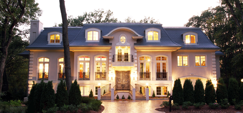 На фото: огромный, трехэтажный, бежевый дом в классическом стиле с облицовкой из цементной штукатурки с