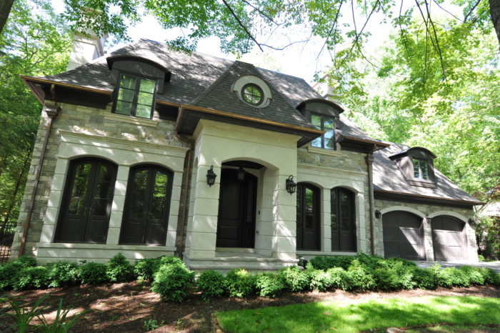 Photo of a large and beige traditional two floor house exterior in Toronto with stone cladding and a hip roof.