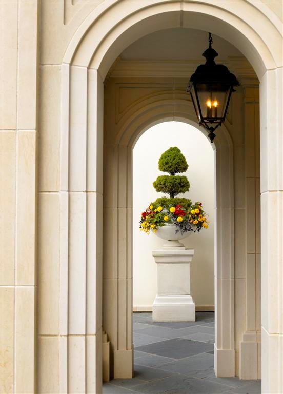 Modelo de fachada beige tradicional grande de dos plantas con revestimiento de piedra