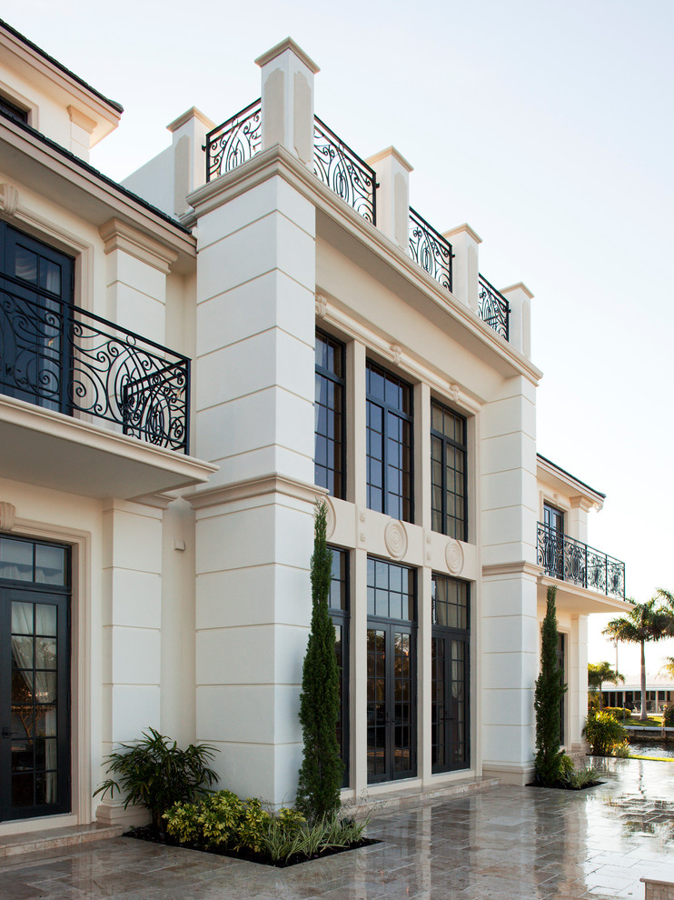 Diseño de fachada de casa beige clásica renovada extra grande de tres plantas con revestimientos combinados y tejado a cuatro aguas