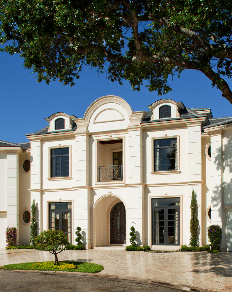 Immagine della villa ampia beige classica a tre piani con rivestimenti misti e tetto a padiglione