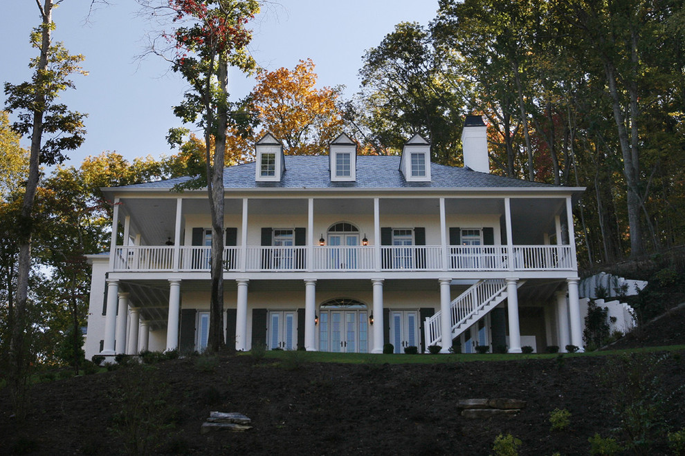 Foto della facciata di una casa classica a due piani con terreno in pendenza