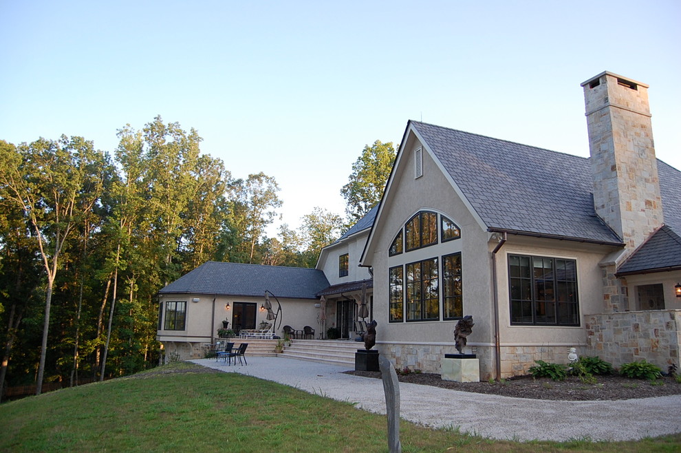 Modelo de fachada de casa beige tradicional de tamaño medio de dos plantas con revestimientos combinados, tejado a dos aguas y tejado de teja de madera